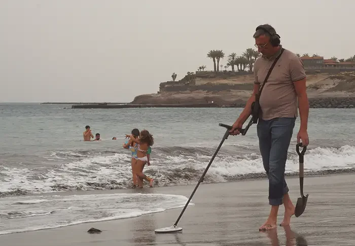 Man with metal detector on a beach