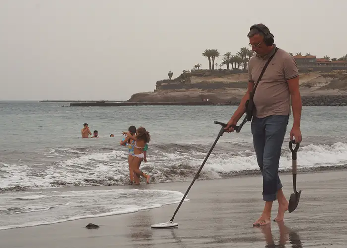 Man with metal detector on a beach