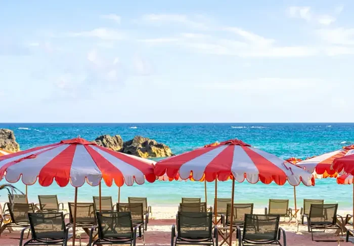 Pink-sand beach and striped umbrellas at Palmetto Beach Club in Bermuda