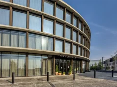 The Clayfield Brings a Contemporary New Stay to Niagara-on-the-Lake Curved glass exterior and main entrance of The Clayfield hotel in Niagara-on-the-Lake, Ontario