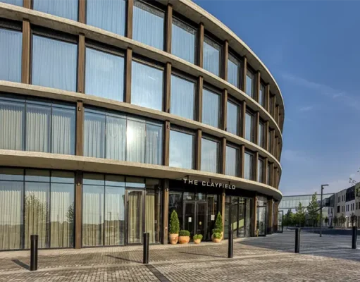 The Clayfield Brings a Contemporary New Stay to Niagara-on-the-Lake Curved glass exterior and main entrance of The Clayfield hotel in Niagara-on-the-Lake, Ontario