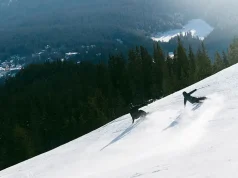 Why LAAX Deserves a Place on Your Swiss Ski Shortlist Skier and snowboarder descending a snowy slope at LAAX ski resort in the Swiss Alps