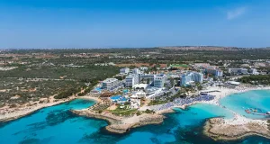 Before you turn a Cyprus holiday into a Cyprus address: what each residence route requires Aerial view of ayia napa coastline with nissi beach and resorts