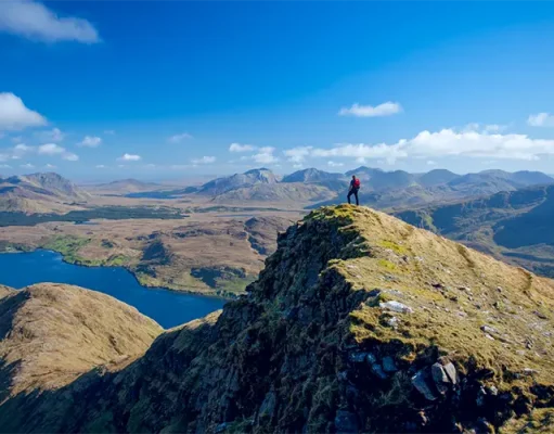 Killary Fjord Named One of Lonely Planet’s Best Travel Experiences for 2027 Walker on the South Ridge of Mweelrea Mountain overlooking Killary Fjord in County Mayo, Ireland, with panoramic views of mountains, lakes, and dramatic coastal landscapes.