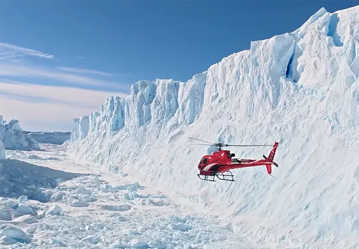 Scenic helicopter flight above Antarctica's snow-covered mountains and glaciers near Union Glacier.