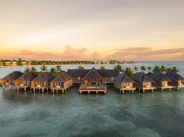 Aerial view of Kuda Villingili Resort Maldives, featuring luxury overwater villas and turquoise waters in North Malé Atoll.