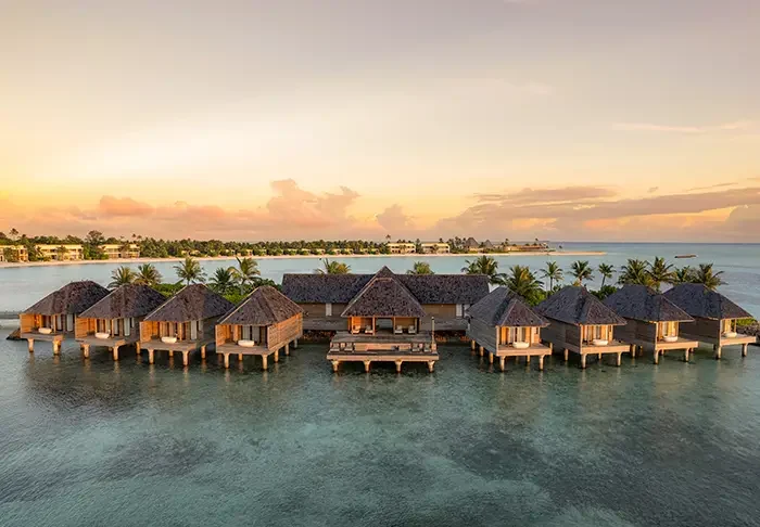 Aerial view of Kuda Villingili Resort Maldives, featuring luxury overwater villas and turquoise waters in North Malé Atoll.