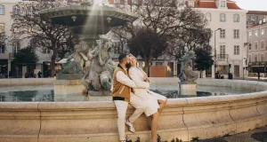 Lisbon Itinerary: How to Spend 3 Days in Lisbon Couple sitting on the rim of the baroque fountain in Rossio square, Lisbon