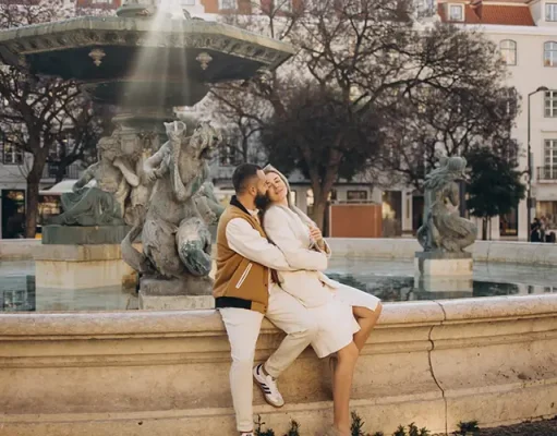Lisbon Itinerary: How to Spend 3 Days in Lisbon Couple sitting on the rim of the baroque fountain in Rossio square, Lisbon