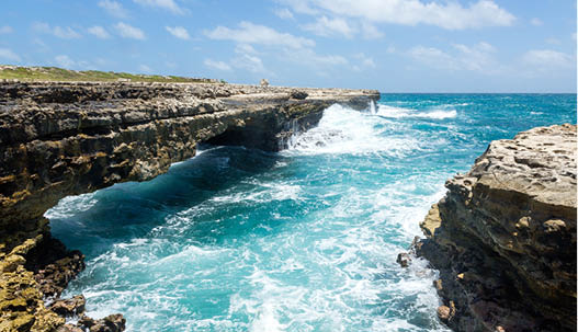 Waves Crashing on Rocks at Devil's Bridge Antigua in Sunshine