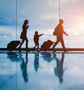 Family at airport travelling with young child and luggage walking to departure gate, girl pointing at airplanes through window, silhouette of people, abstract international air travel concept
