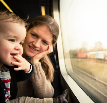 Mum and cute son travelling by railway in Denmark, Scandinavia. Public transportaion eg. by train or bus is a very popular way to commute or travel around in Europe.