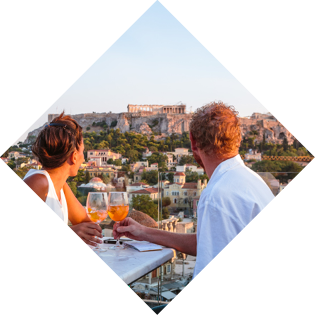 Couple drinking and enjoying the view of the Acropolis at sunset. Athens, Greece