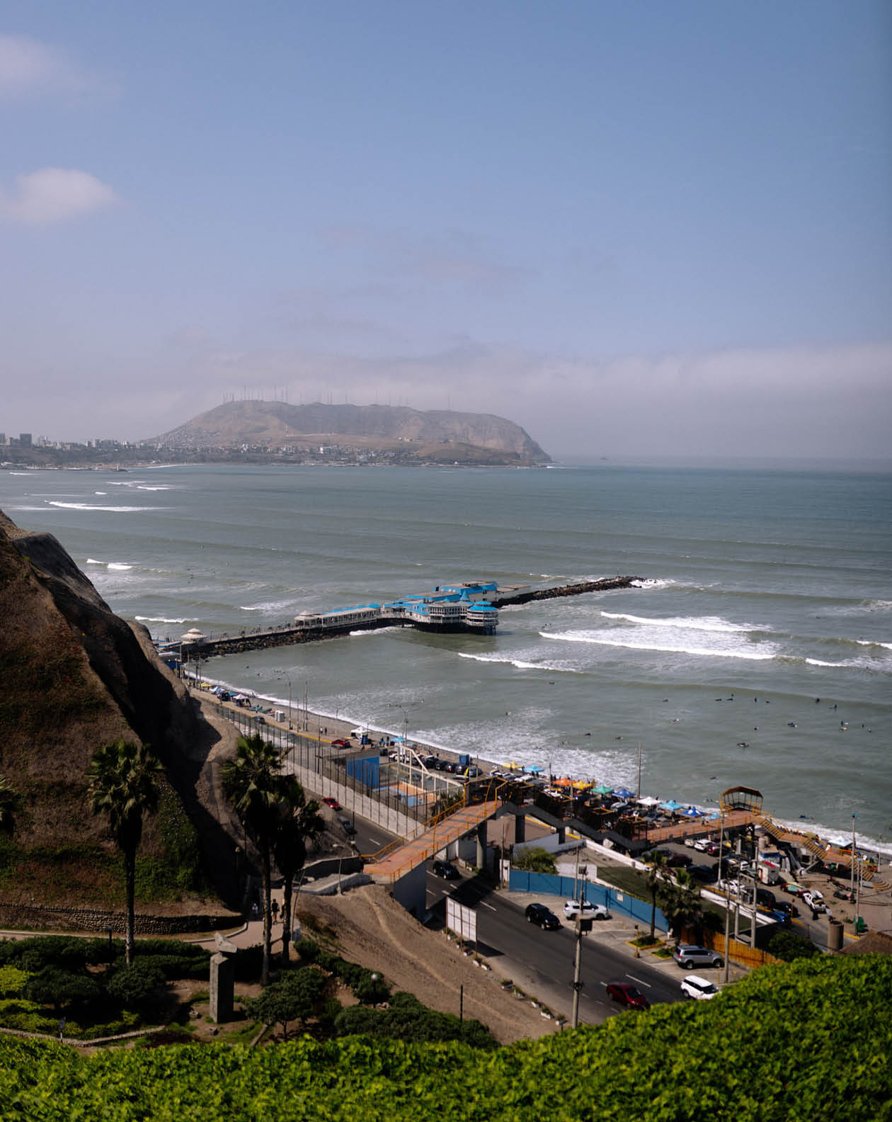A beautiful view of the ocean with a pier and a mountain in the background. Description generated by AI
