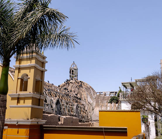A large building with a yellow wall and a clock tower. Description generated by AI