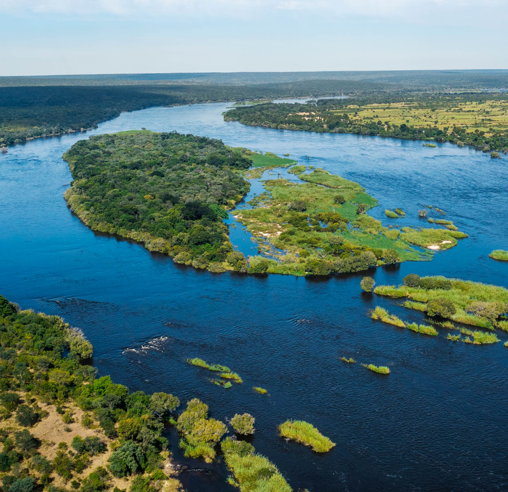A large body of water with a green island in the middle. Description generated by AI