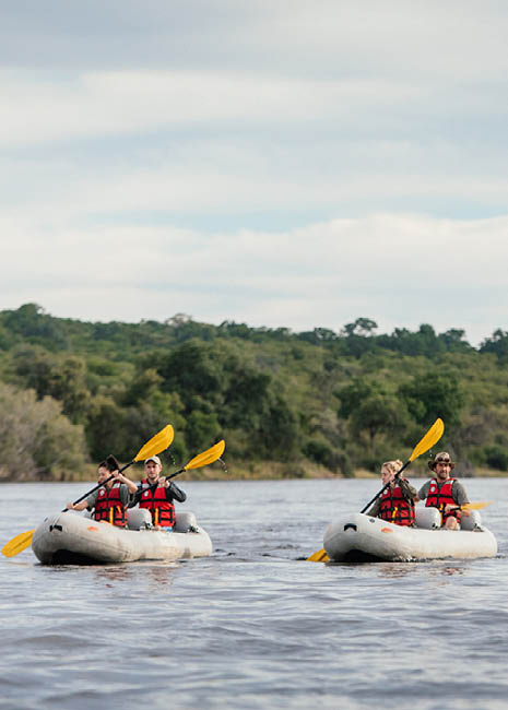 Four people in canoes on a lake. Description generated by AI