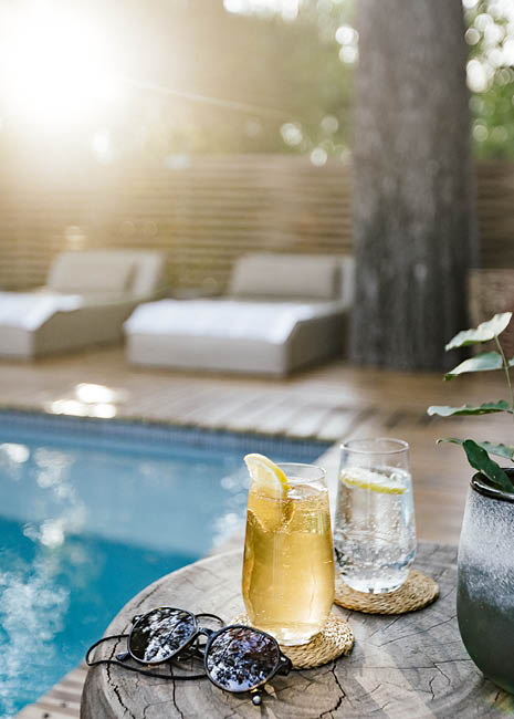 A glass of lemonade and a glass of water are on a table. Description generated by AI