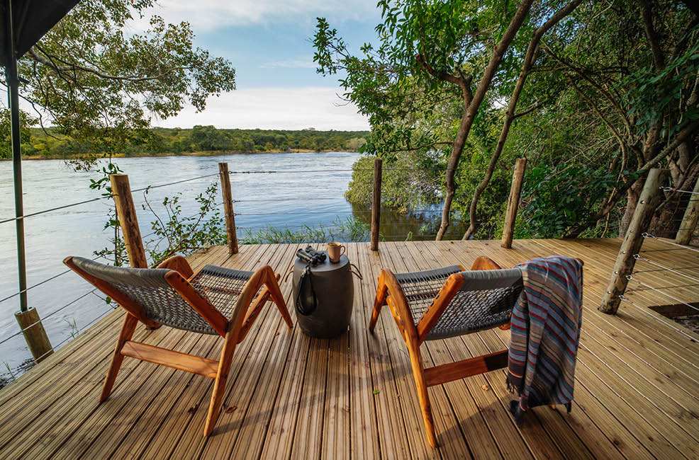 A wooden deck with a table and chairs. Description generated by AI