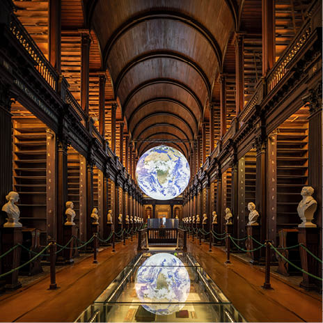 A large globe is suspended from the ceiling of a building. Description generated by AI