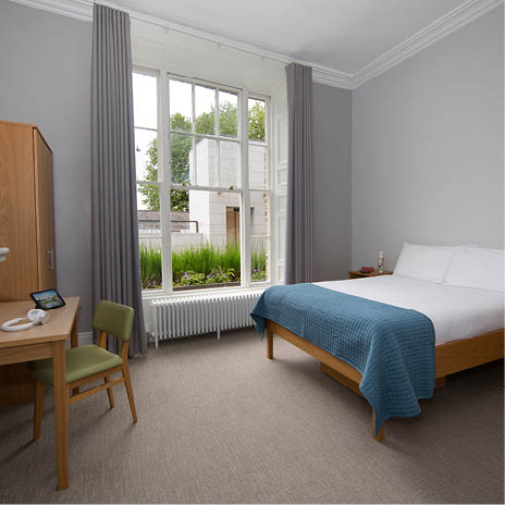 A bedroom with a bed, desk, and chair. Description generated by AI