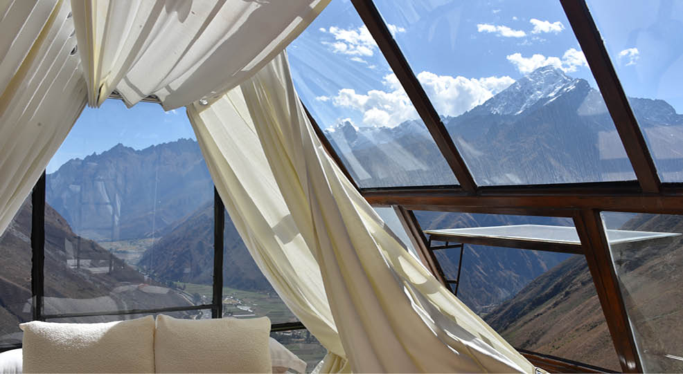 A bedroom with a canopy bed and a mountain view. Description generated by AI