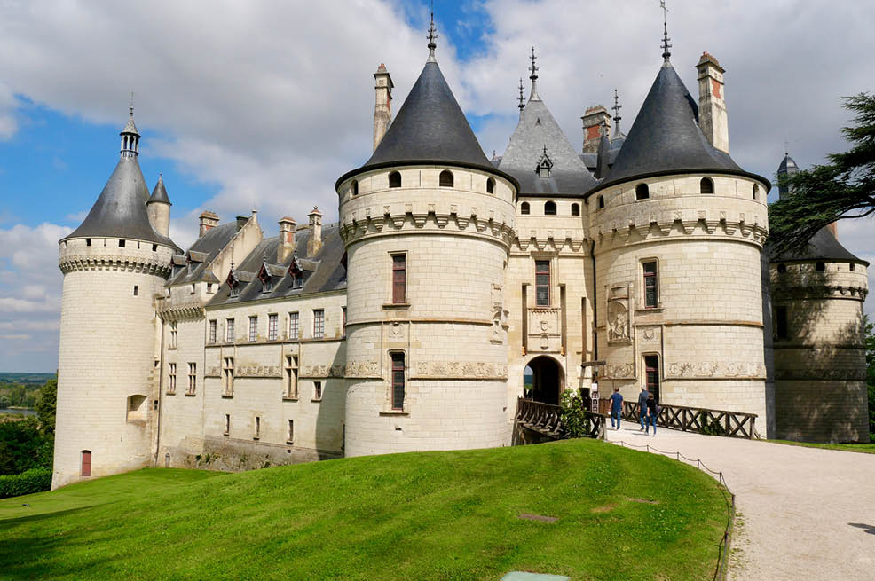 A large castle with a green roof and a blue sky. Description generated by AI