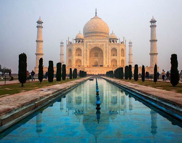 A large white building with a blue pool in front of it. Description generated by AI