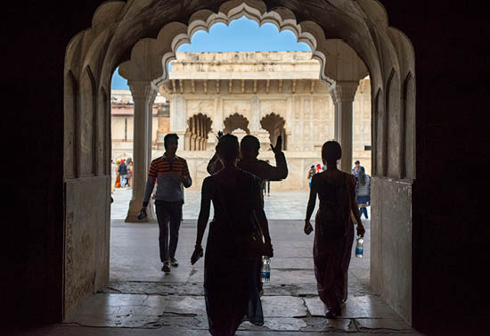 People walking through a courtyard. Description generated by AI