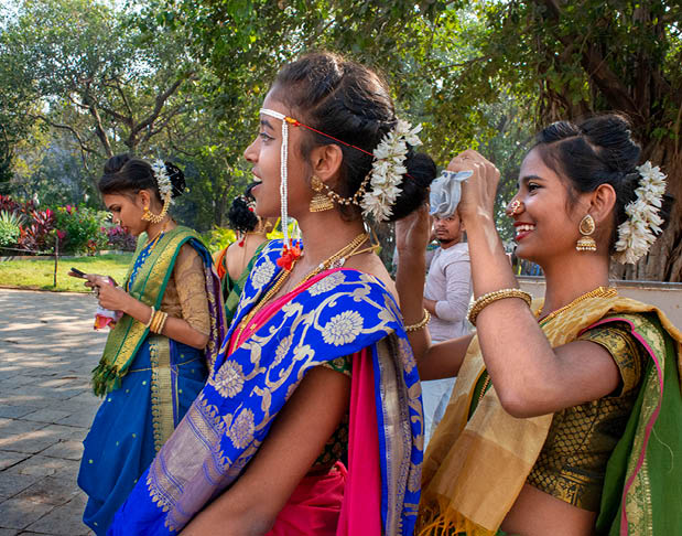 Three women wearing colorful dresses and jewelry. Description generated by AI