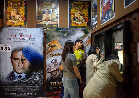 A group of people standing in front of a movie poster. Description generated by AI