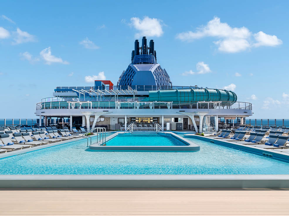 A large cruise ship with a blue pool on the deck. Description generated by AI