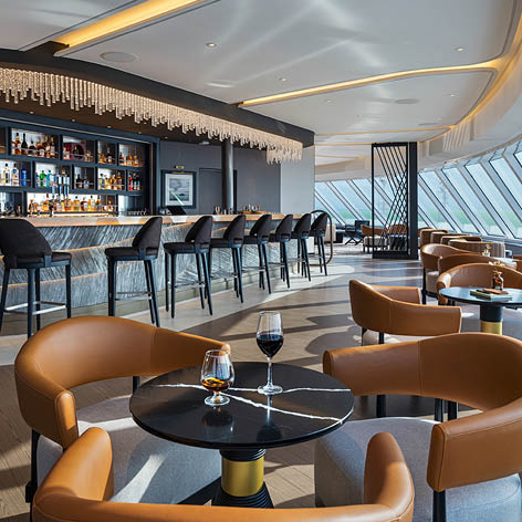 A bar with a long counter and several stools. Description generated by AI