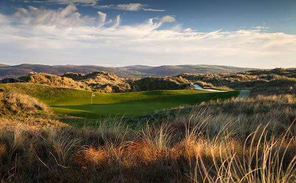 A green golf course with a hole in the middle. Description generated by AI