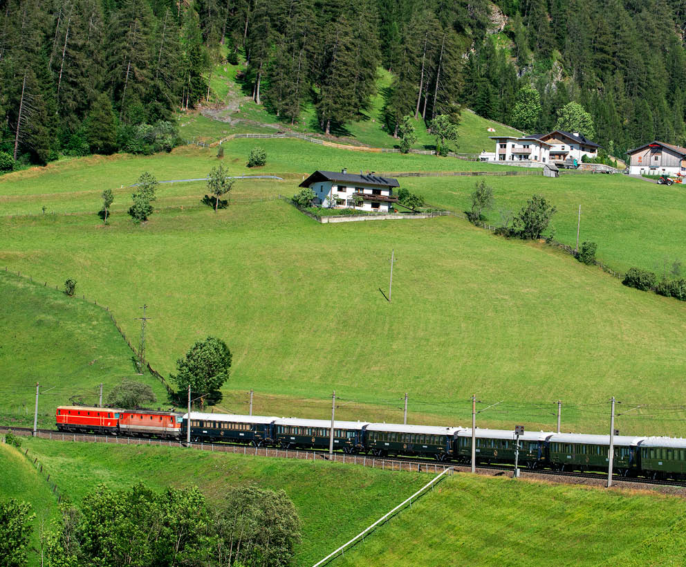 Train running along Renon plateau with Dolomites scenery. Belmond Venice Simplon Orient Express luxury train. Santa Maddalena, Dolomites Mountains landscape, Tyrol, Alps, Italy   An icon of art deco design. Rekindle the romance of the rails as you travel between Europe’s most captivating cities. The Venice Simplon-Orient-Express, or VSOE, is a private luxury train service from London to Venice and other European cities. It is currently owned by Belmond, which operates 45 luxury hotels, restaurants, tourist trains and river cruises in 24 countries. It was agreed in December 2018 for the service to be acquired by LVMH  