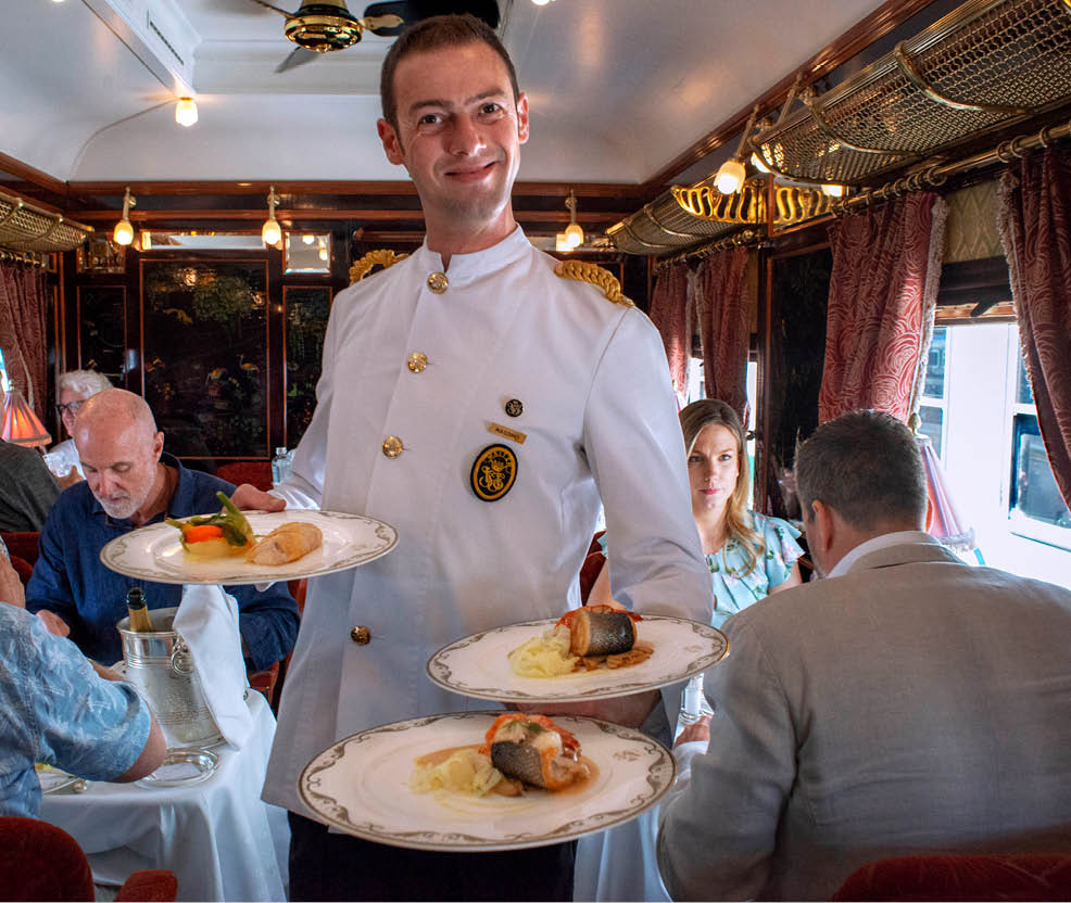 A waiter serves the dinner inside the art deco restaurant wagon of the train Belmond Venice Simplon Orient Express luxury train. Salmon cabbage and potatoes  Be enticed by the flavours of Europe aboard the Venice Simplon-Orient-Express. Set menus that celebrate exceptional artisanal cuisine are an inclusive part of your trip. Drinks and   la carte options are also available at an additional charge. Don’t forget to inform us of dietary requirements in advance for a culinary journey that’s tailored to you.  An icon of art deco design. Rekindle the romance of the rails as you travel between Europe’s most captivating cities. The Venice Simplon-Orient-Express, or VSOE, is a private luxury train service from London to Venice and other European cities. It is currently owned by Belmond, which operates 45 luxury hotels, restaurants, tourist trains and river cruises in 24 countries. It was agreed in December 2018 for the service to be acquired by LVMH 