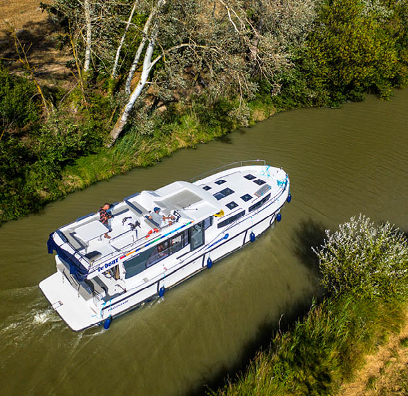 Aerial view of a boat in the Canal du Midi at Le Somail Aude South of France southern waterway waterways holidaymakers queue for a boat trip on the river, France, Europe  Tour with a rental boat from the Le Boat company from Homps to the nine Fonseranes locks in B ziers and back to Carcassonne.  