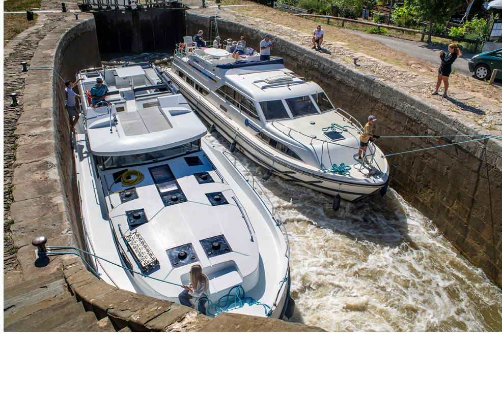 Boat crossing the cluse d´Ognon Ognon look. Canal du Midi at village of Olonzac Aude South of France southern waterway waterways holidaymakers queue for a boat trip on the river, France, Europe  Tour with a rental boat from the Le Boat company from Homps to the nine Fonseranes locks in B ziers and back to Carcassonne.  