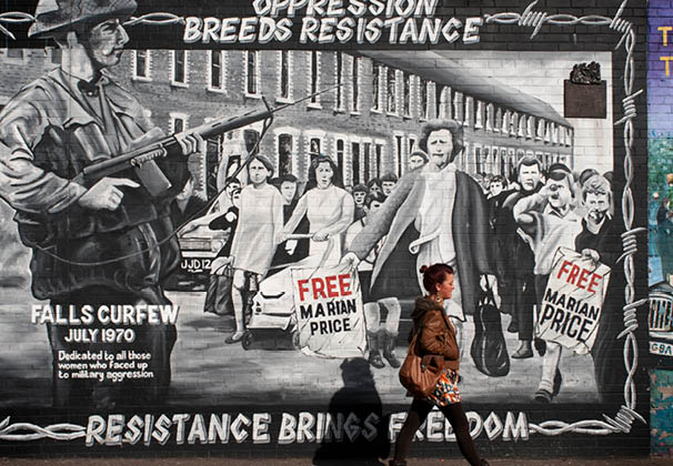 Political mural in Falls road street, Belfast, Northern Ireland, UK. Oppression breeds resistance; resistance brings freedom. Mural in the Falls Road, a Catholic neighborhood of Belfast. Ulster. Northern Ireland. Falls Curfew July 1970 Dedicated to all those women who faced up to military aggression. 