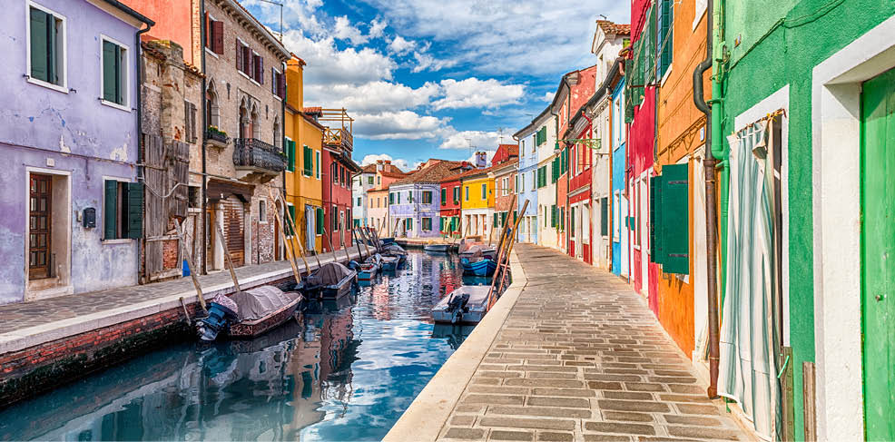 Colourful painted houses along the canal on the island of Burano, Venice, Italy. The island is a popular attraction for tourists due to its picturesque architecture
