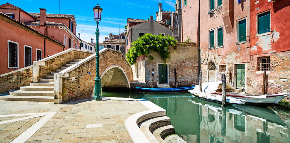 Venice cityscape, narrow water canal, bridge, boats, and traditional buildings. Italy, Europe.