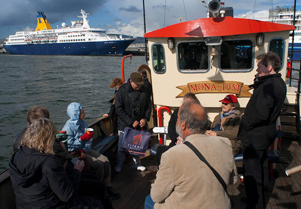 The Red Hulled Tourist Boat Mona Moored in The River Lagan in Belfast Northern Ireland United Kingdom UK. Saga Pearl II big cruise docked at Belfast.