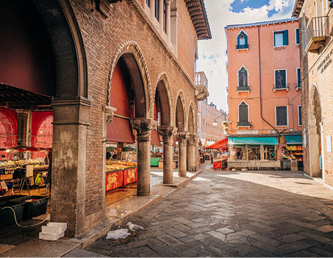 Early morning view of the famous Rialto Market in Venice with authentic Venetian atmosphere, historic architecture and traditional local market scene near the Grand Canal.