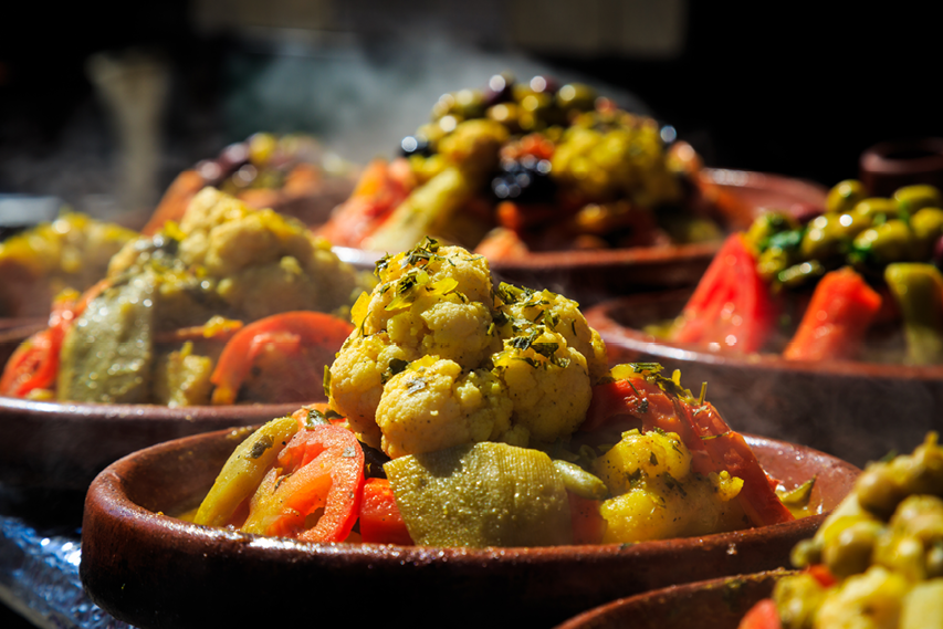 A lot of warm tagines with delicious vegetables on a market in Morocco