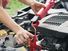 A woman is working on a car, holding a red tool to the engine. AI generated content