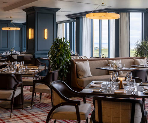 A restaurant with a large window and blue walls. The table is set with silverware, glasses, and a potted plant. AI generated content