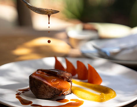 A person is pouring sauce on a plate with meat and vegetables. AI generated content