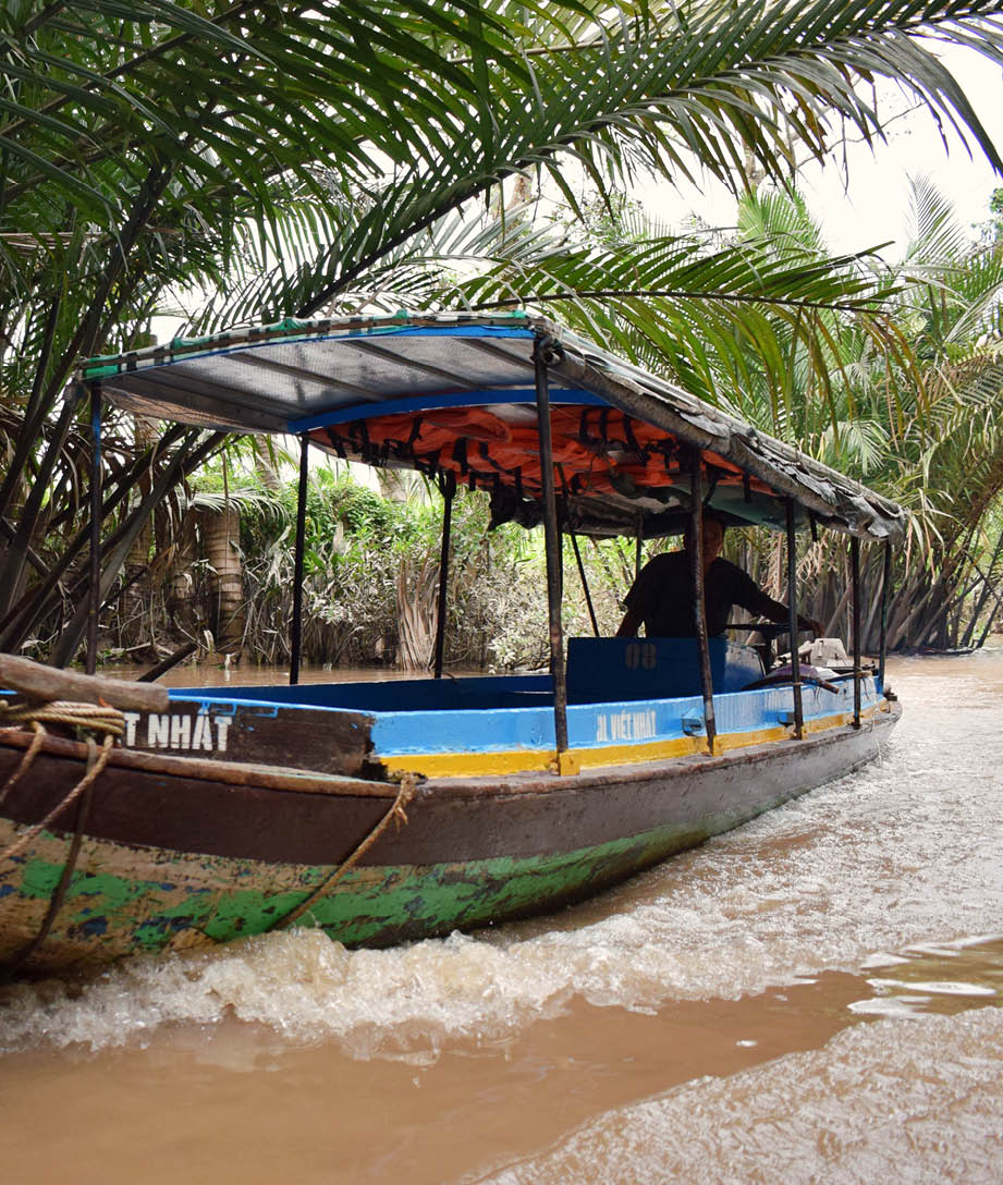 A boat with a blue and yellow canopy is traveling down a river. AI generated content