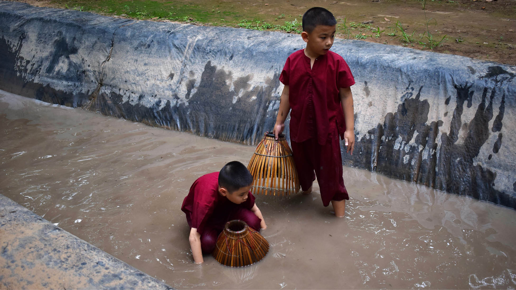 Two children playing in a muddy puddle, one holding a basket. AI generated content