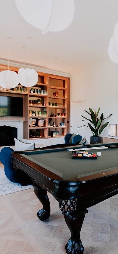 A pool table with a green top is in a living room. AI generated content